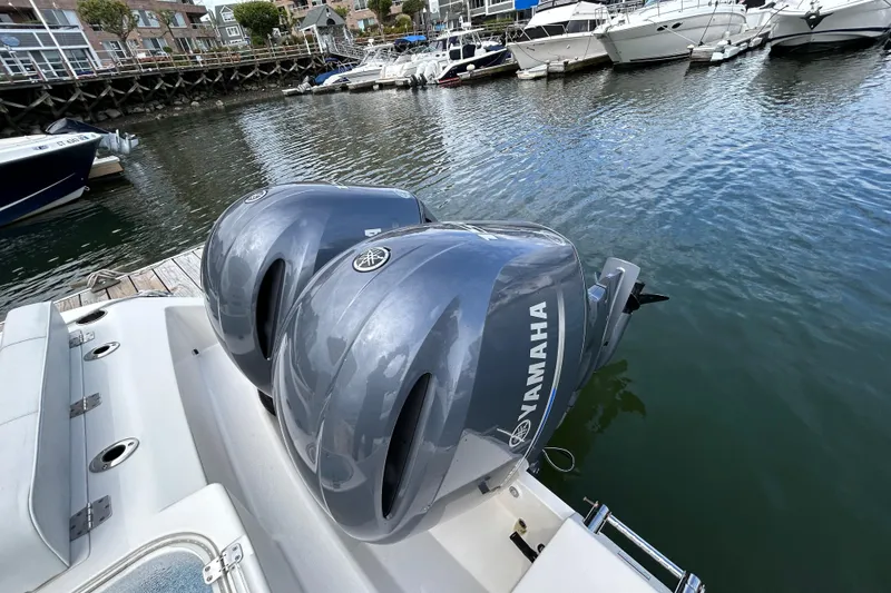 Slide: The Image of 2023 Cobia 240 Center Console with twin Yamaha outboard engines docked at marina. - 5