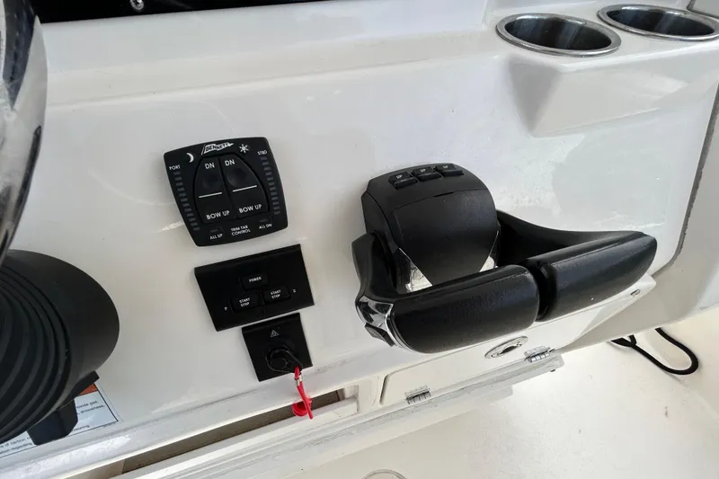 Slide: The Image of Control panel of 2023 Cobia 240 Center Console boat with throttle and trim tabs. - 8
