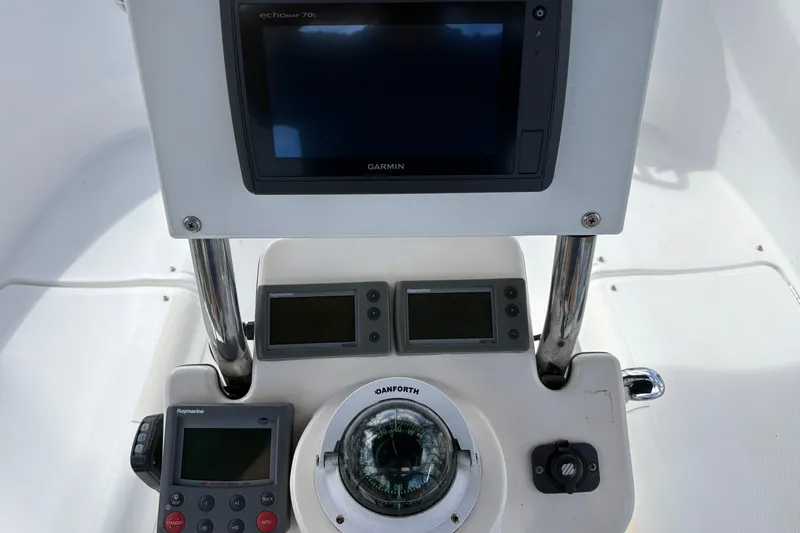 Slide: The Image of Cockpit navigation instruments on a 2006 Hunter 31 sailboat, featuring Garmin and Raymarine displays. - 15