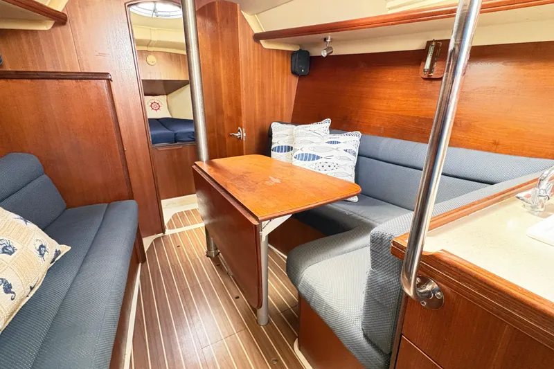 Slide: The Image of Interior of 2006 Hunter 31 sailboat with wooden finishes and cozy seating area. - 3