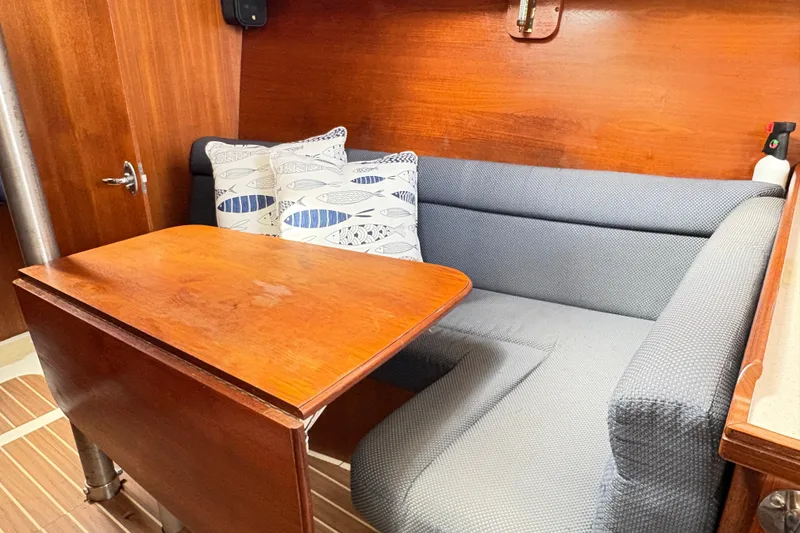 Slide: The Image of Cozy interior of 2006 Hunter 31 sailboat with wooden table and cushioned seating. - 4