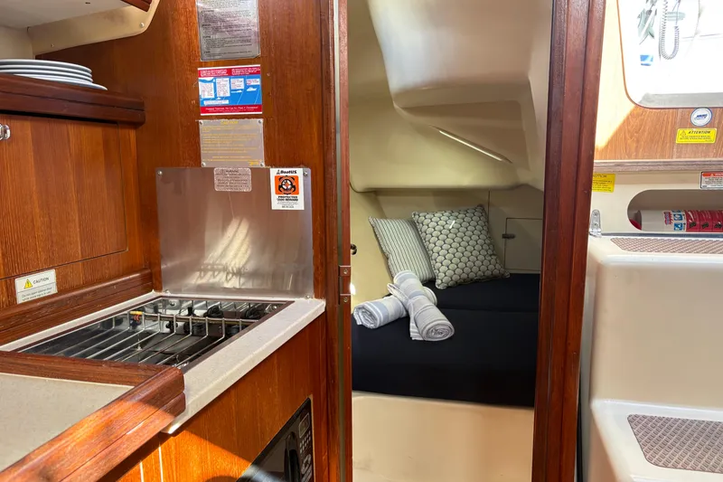 Slide: The Image of Interior of a 2006 Hunter 31 sailboat featuring a cozy cabin and compact kitchen area. - 5