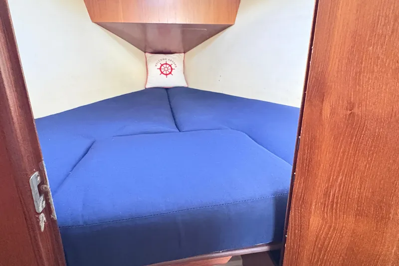 Slide: The Image of Cozy cabin interior of 2006 Hunter 31 sailboat with blue bedding and nautical decor. - 6