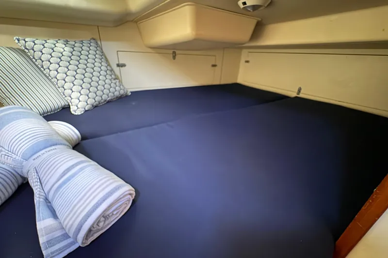 Slide: The Image of Cozy cabin interior of 2006 Hunter 31 sailboat with blue bedding and striped pillows. - 7