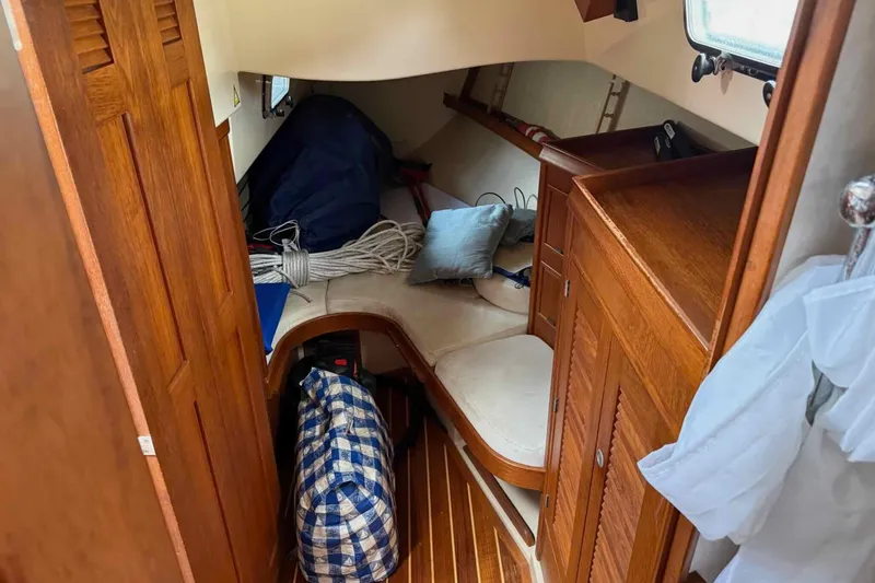 Slide: The Image of 1998 Island Packet 40 sailboat interior with wooden cabinetry and storage space. - 10