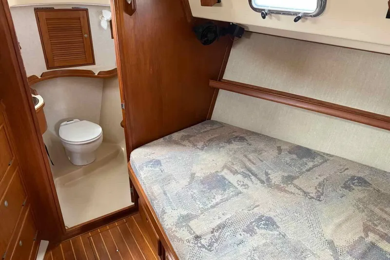 Slide: The Image of 1998 Island Packet 40 interior with wooden cabinetry, bed, and compact bathroom. - 11