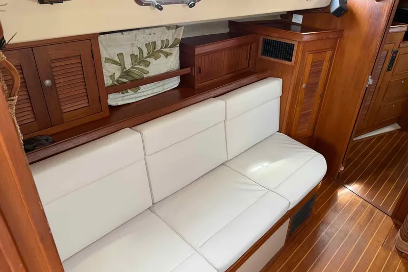 Slide: The Image of Interior of 1998 Island Packet 40 yacht with white seating and wooden cabinetry. - 26