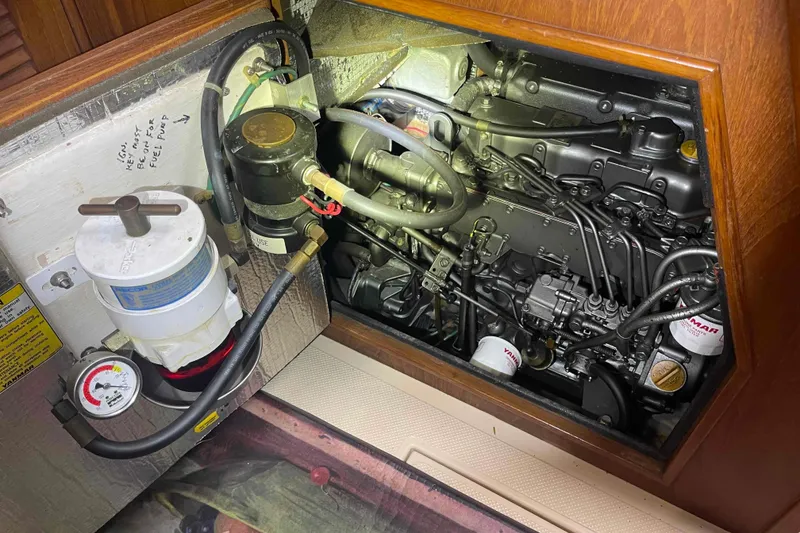 Slide: The Image of Engine compartment of a 1998 Island Packet 40 sailboat, showcasing detailed mechanical components. - 30