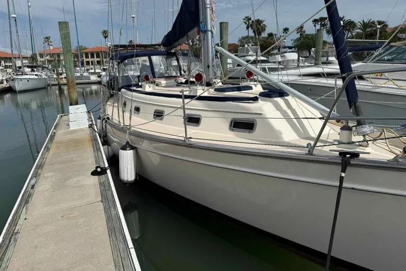 Slide: The Image of 1998 Island Packet 40 sailboat docked at marina with clear skies and palm trees. - 38