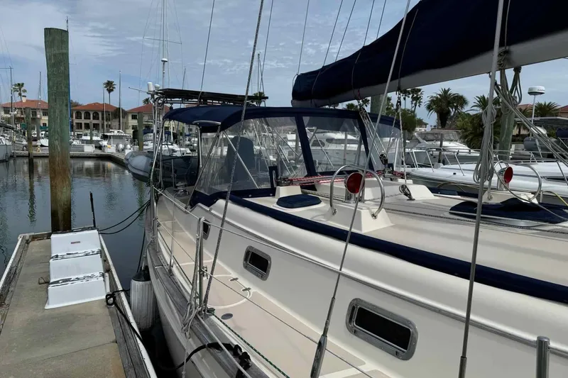 Slide: The Image of 1998 Island Packet 40 sailboat docked at marina with clear skies and palm trees. - 39