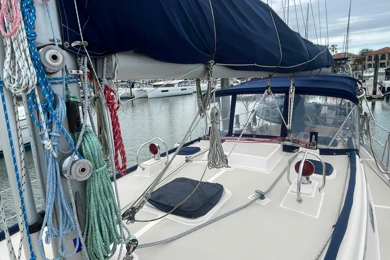 Slide: The Image of 1998 Island Packet 40 sailboat deck with rigging and blue canopy in marina. - 41