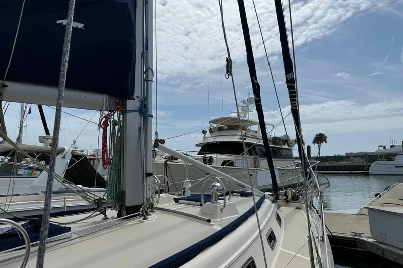 Slide: The Image of 1998 Island Packet 40 sailboat docked at marina under a partly cloudy sky. - 44