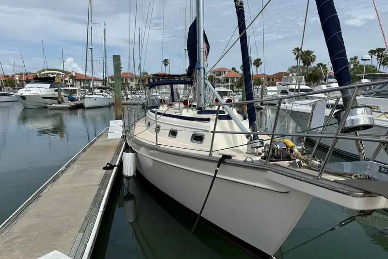 Slide: The Image of 1998 Island Packet 40 sailboat docked in a marina, surrounded by other boats. - 46