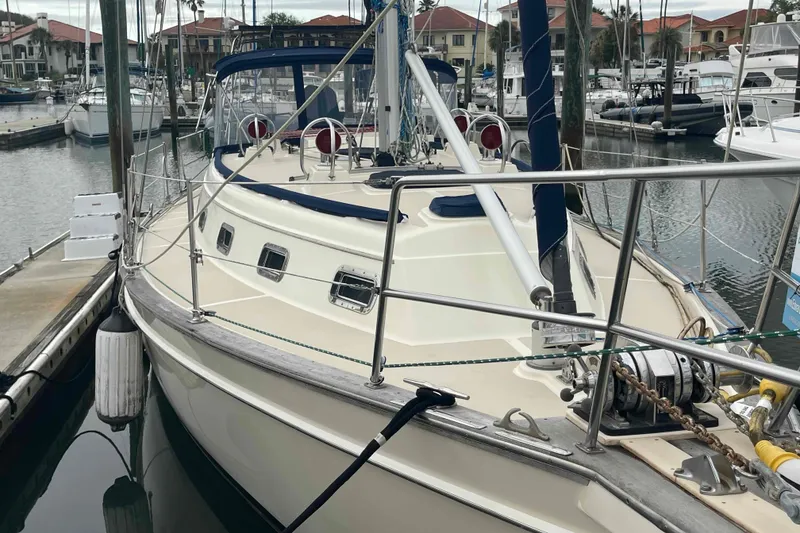 Slide: The Image of 1998 Island Packet 40 sailboat docked in a marina, showcasing its deck and rigging. - 49
