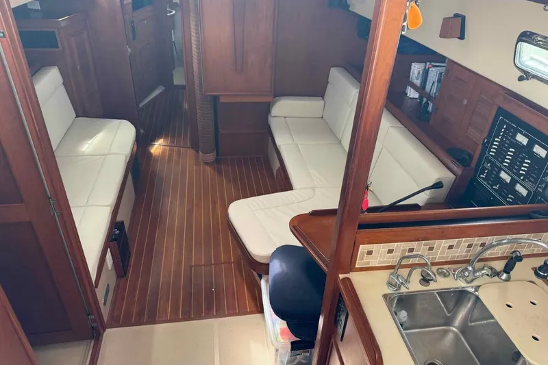 Slide: The Image of Interior of 1998 Island Packet 40 yacht with wood flooring and white seating. - 5