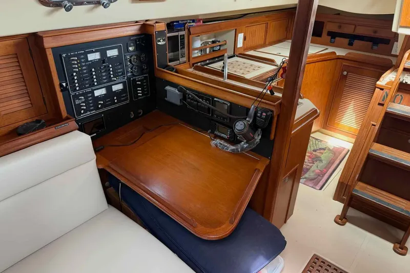 Slide: The Image of Navigation station of a 1998 Island Packet 40 yacht with control panels and wooden cabinetry. - 8