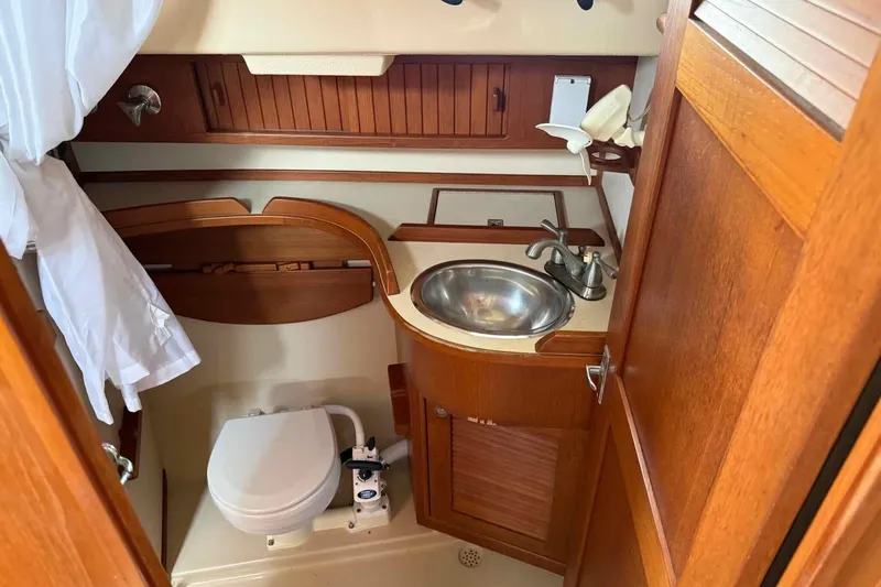 Slide: The Image of 1998 Island Packet 40 yacht bathroom with wooden cabinetry and stainless steel sink. - 9
