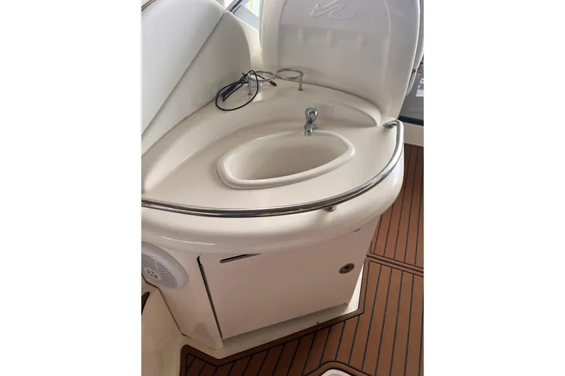 Slide: The Image of 2005 Sea Ray 340 Sundancer boat sink with storage cabinet on teak flooring. - 16