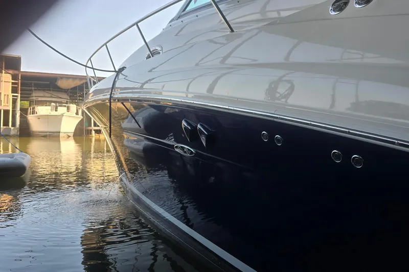 Slide: The Image of 2005 Sea Ray 340 Sundancer yacht docked in marina, reflecting sunlight on water. - 27