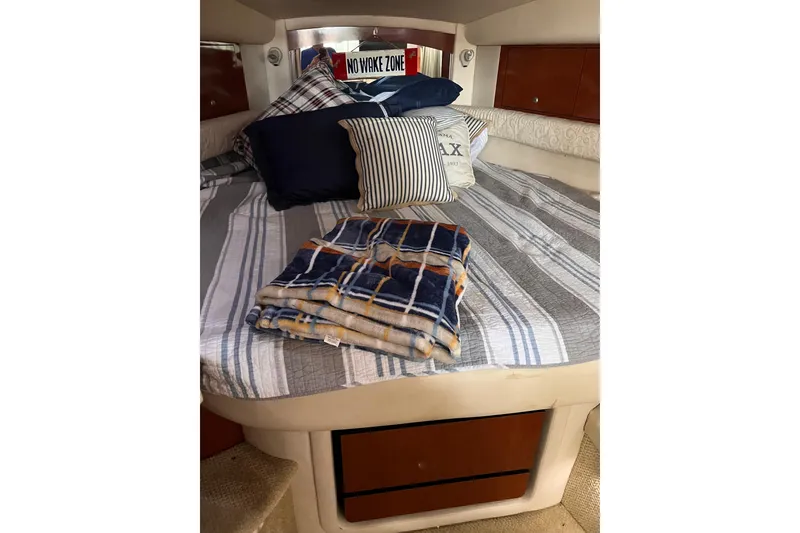 Slide: The Image of Cozy cabin interior of 2005 Sea Ray 340 Sundancer with striped bedding and pillows. - 3