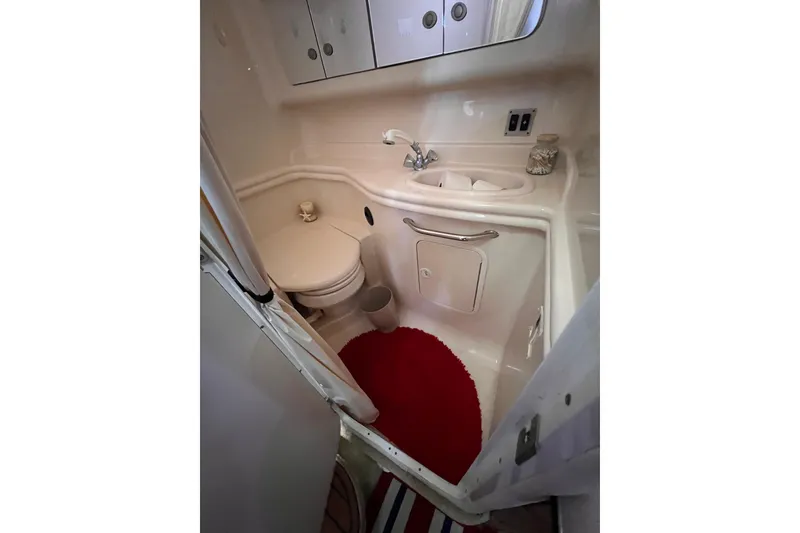 Slide: The Image of 2005 Sea Ray 340 Sundancer bathroom with sink, toilet, and red rug. - 5