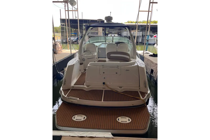 Slide: The Image of 2005 Sea Ray 340 Sundancer yacht docked, showcasing spacious deck and sleek design. - 6