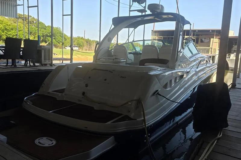 Slide: The Image of 2005 Sea Ray 340 Sundancer docked in a marina, showcasing sleek design and luxury features. - 7