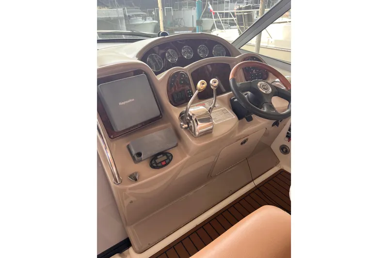 Slide: The Image of 2005 Sea Ray 340 Sundancer helm with steering wheel and navigation controls. - 9
