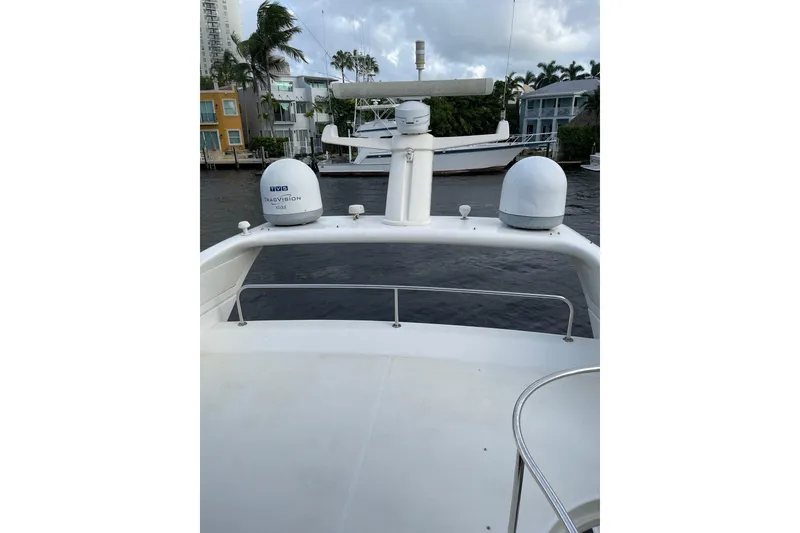 Slide: The Image of Azimut 46 Flybridge MY 2000 yacht with radar and satellite domes, docked near waterfront homes. - 10