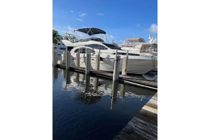 Slide: The Image of Azimut 46 Flybridge MY 2000 yacht docked at marina under clear blue sky. - 2