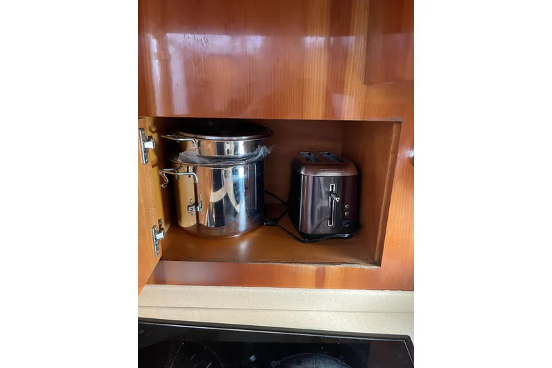 Slide: The Image of Kitchen cabinet with a stainless steel pot and toaster on Azimut 46 Flybridge MY, 2000. - 49