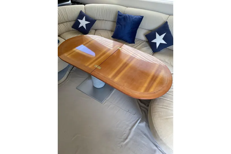 Slide: The Image of Luxurious Azimut 46 Flybridge MY 2000 interior with elegant wooden table and star-themed cushions. - 68