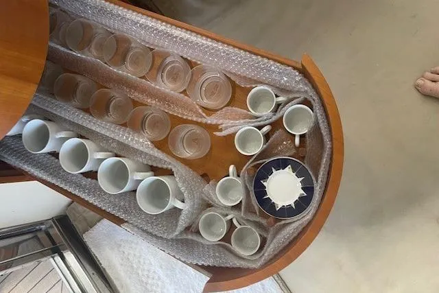 Slide: The Image of Glassware and mugs neatly arranged in a wooden drawer on a 2000 Azimut 46 Flybridge yacht. - 78