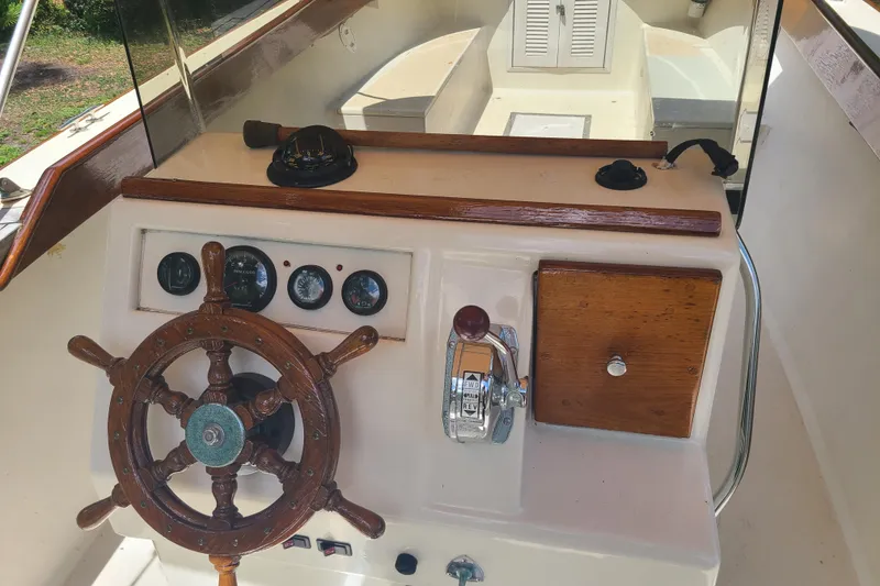 Slide: The Image of 1964 Holmes 25 Cuddy boat dashboard with wooden steering wheel and vintage controls. - 14