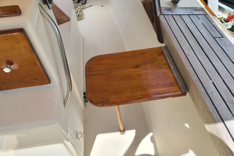 Slide: The Image of 1964 Holmes 25 Cuddy boat interior with wooden foldable table and seating area. - 21