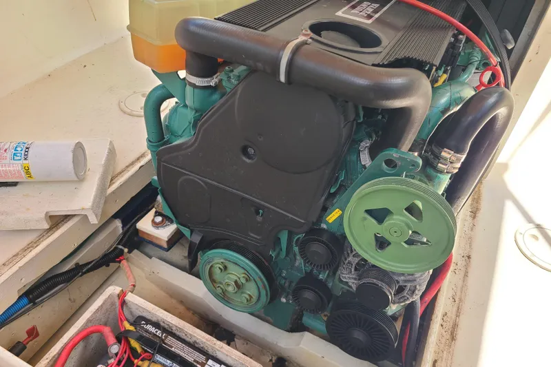 Slide: The Image of Engine compartment of a 1964 Holmes 25 Cuddy boat, showcasing mechanical components and wiring. - 24