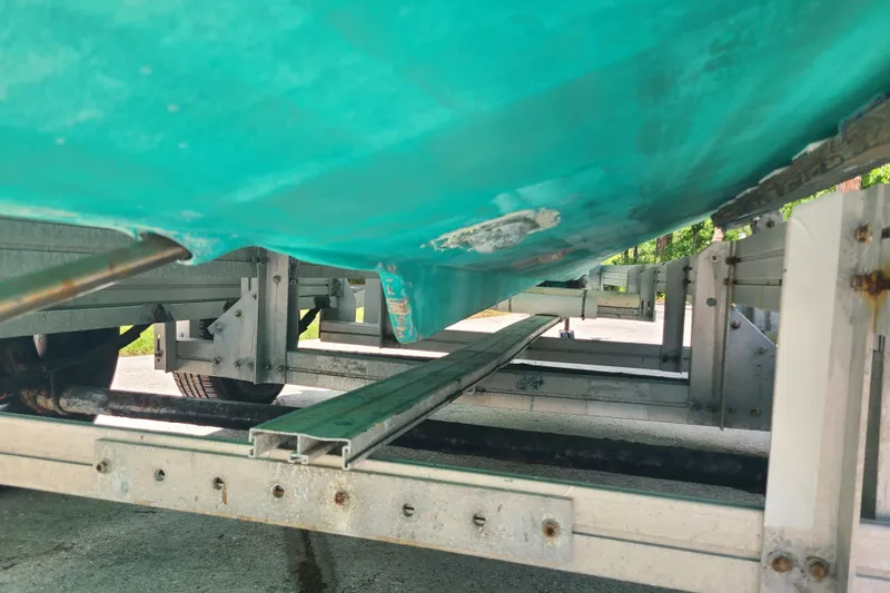 Slide: The Image of 1964 Holmes 25 Cuddy boat underside on trailer, showing hull and support structure. - 27