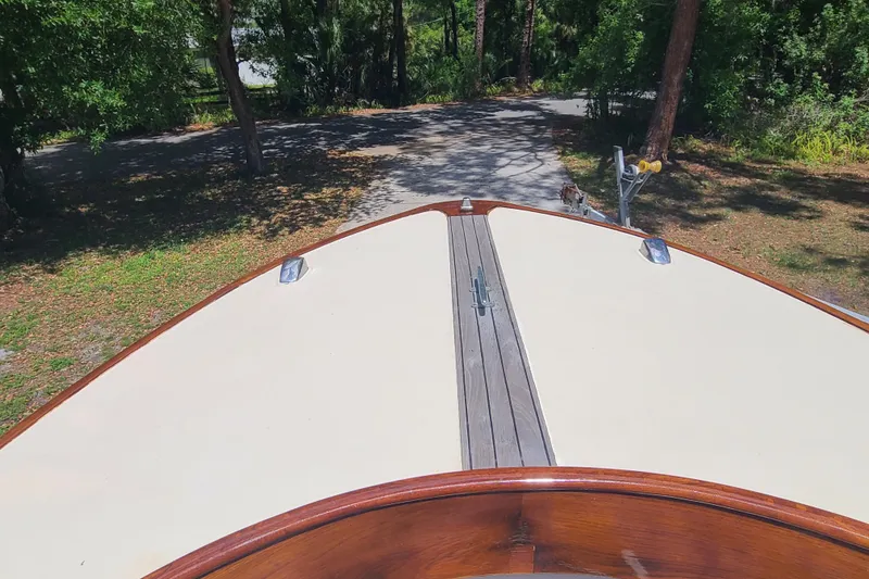 Slide: The Image of 1964 Holmes 25 Cuddy boat on trailer, surrounded by trees and sunlight. - 9