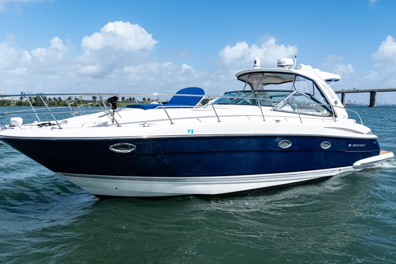 The Image of 2008 Monterey 400 Sport Yacht cruising on open water under a clear blue sky. - 1