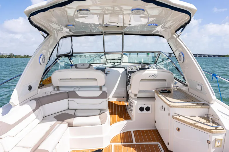 Slide: The Image of 2008 Monterey 400 Sport Yacht interior with luxurious seating and helm, cruising on open water. - 24