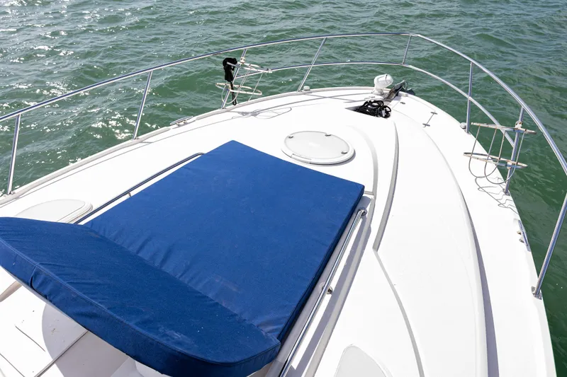 Slide: The Image of 2008 Monterey 400 Sport Yacht deck with blue sunbed on calm water. - 35