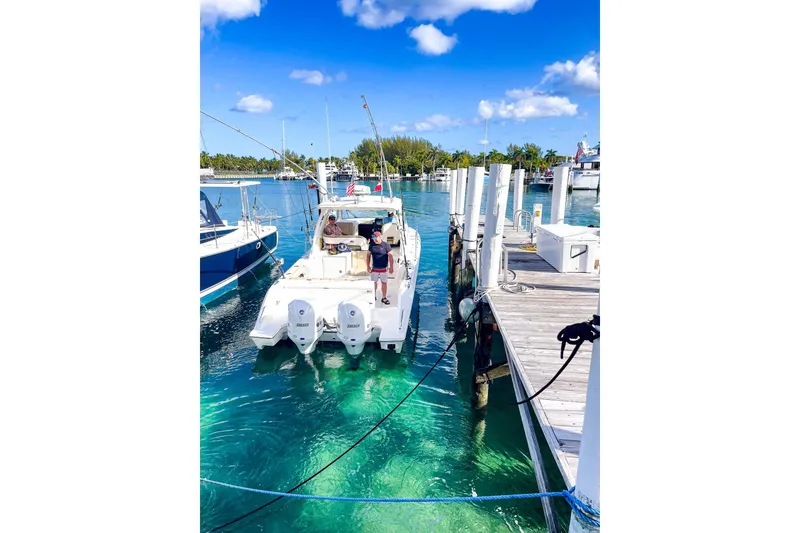 Slide: The Image of 2020 Pursuit OS 325 Offshore docked at marina with clear blue water. - 13