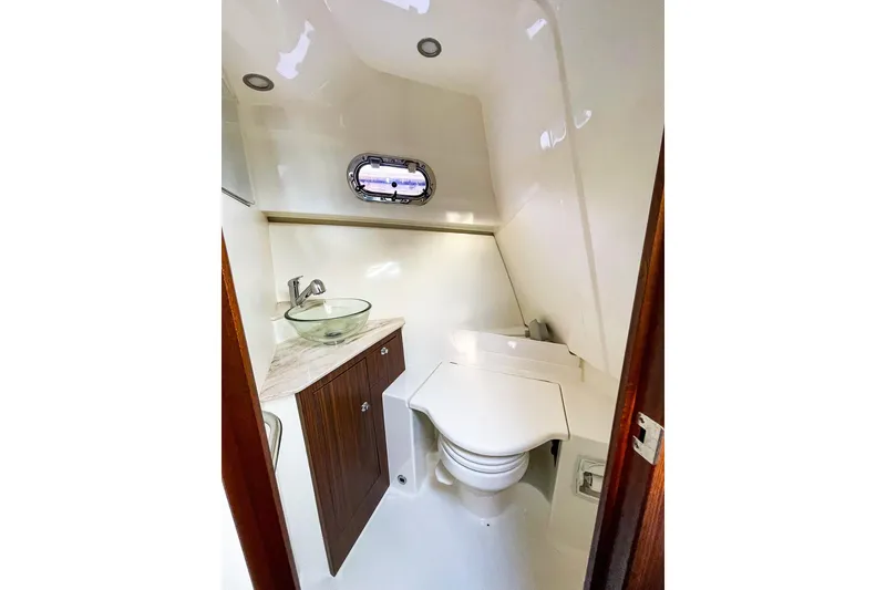 Slide: The Image of 2020 Pursuit OS 325 Offshore boat bathroom with modern sink and compact toilet. - 16