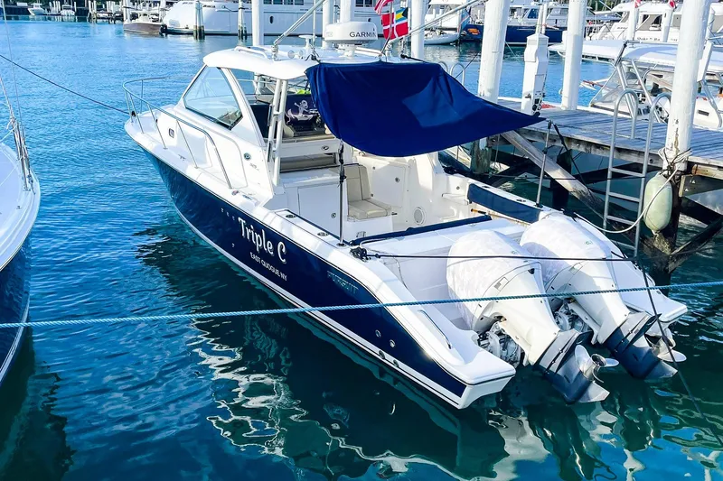 Slide: The Image of 2020 Pursuit OS 325 Offshore boat docked at marina with twin engines. - 2
