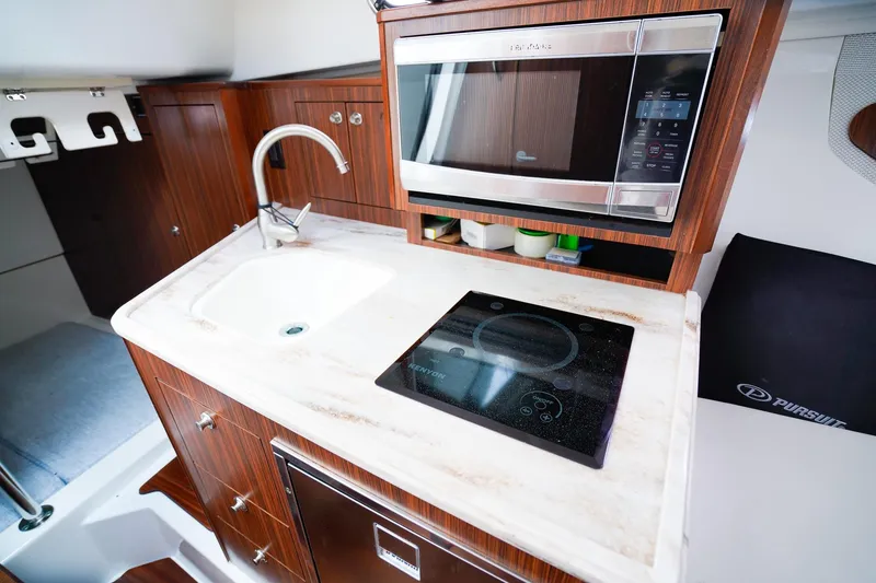 Slide: The Image of 2020 Pursuit OS 325 Offshore yacht kitchen with sink, stove, and microwave. - 29