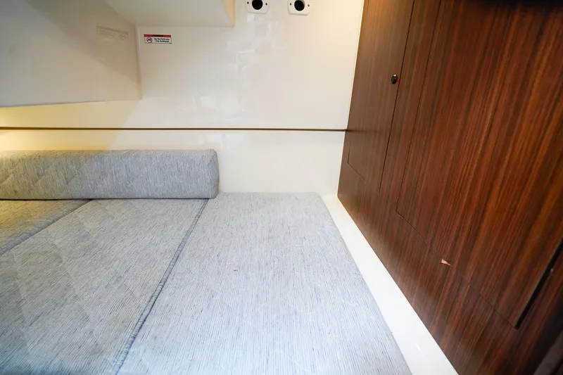 Slide: The Image of Interior cabin of 2020 Pursuit OS 325 Offshore with wooden paneling and cushioned seating. - 31