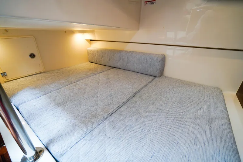 Slide: The Image of 2020 Pursuit OS 325 Offshore cabin interior with cozy bedding and soft lighting. - 32