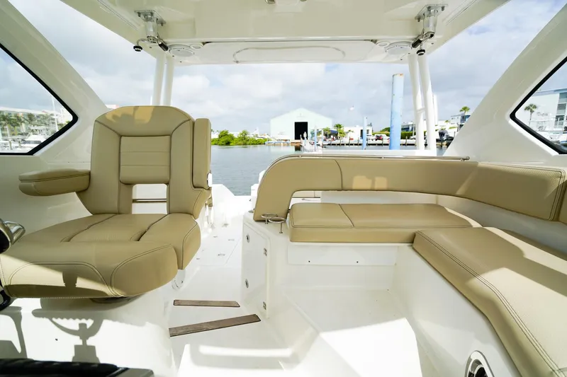 Slide: The Image of 2020 Pursuit OS 325 Offshore boat interior with beige seating and waterfront view. - 33