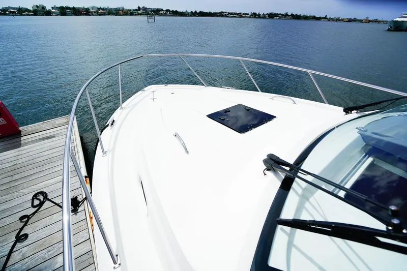 Slide: The Image of 2020 Pursuit OS 325 Offshore boat docked by the water, showcasing sleek design and railing. - 39