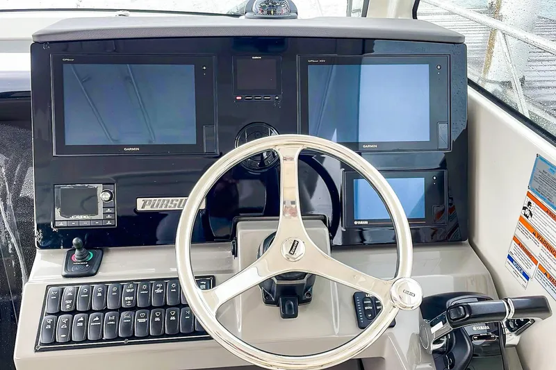Slide: The Image of Helm of 2020 Pursuit OS 325 Offshore with Garmin displays and Yamaha controls. - 9